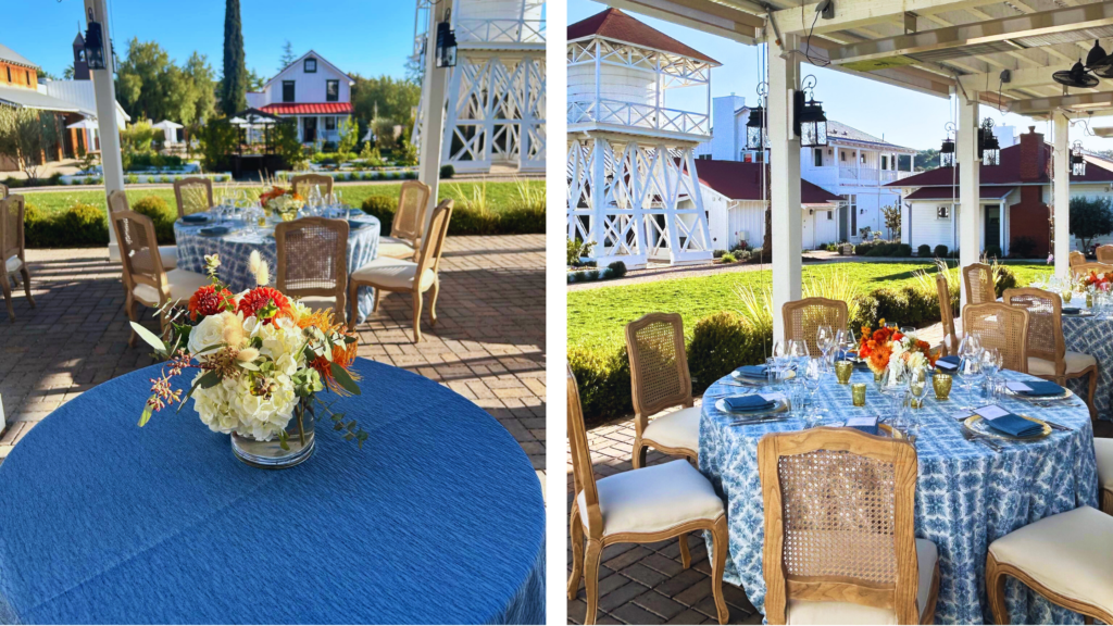 round table set up outside with blue tablecloths, flowers, and place settings